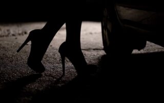 Prostitution Laws in Ottawa Ontario portrayed by a prostitute's legs near a car door in the shadows